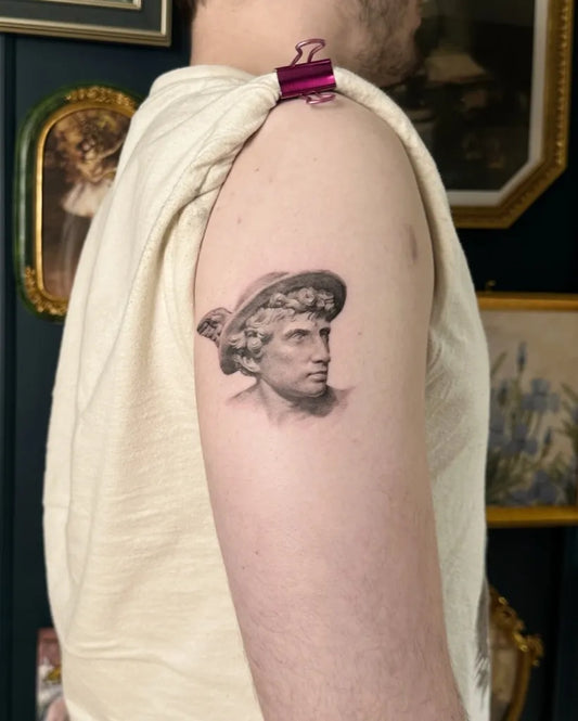 Small Micro Realism Hermes bust on Men Arm Tattoo by @louie.tattoos