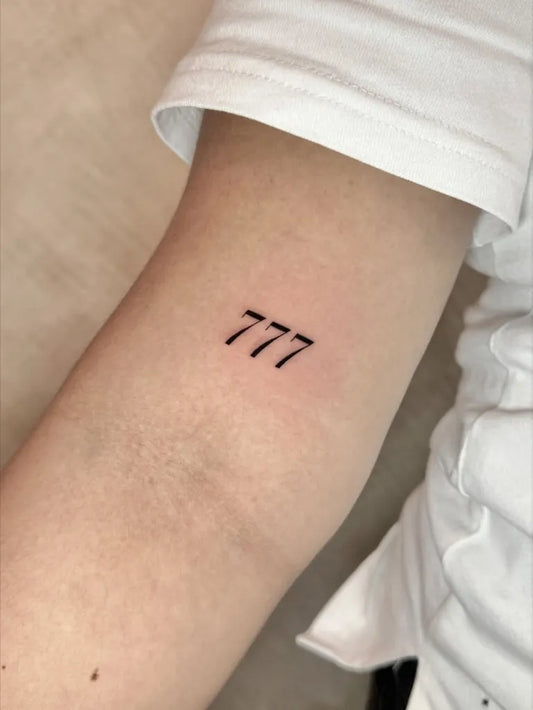 Small Minimalist 777 Tattoo on Women Arm by @timeless_tattooandpiercing