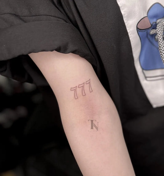 Small Minimalist Angel Number 777 Tattoo on Women Arm by @nazanin.tntattoo