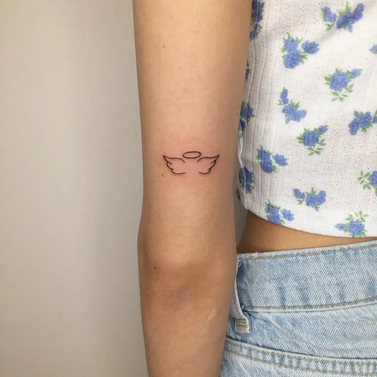 Small Minimalist Angel Wings with Halo Tattoo on Women Arm by @amir.inks