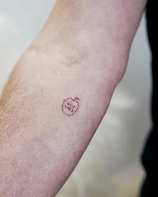 Small Minimalist Apple with Bite Mark on Women Forearm Tattoo by @davekulla.tattoo