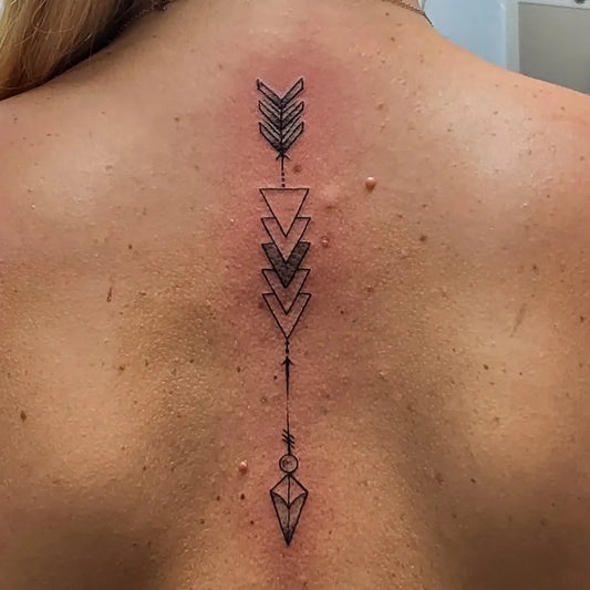 Small Minimalist Arrow Triangles Tattoo on Women Back by @tattoo_tommywhite