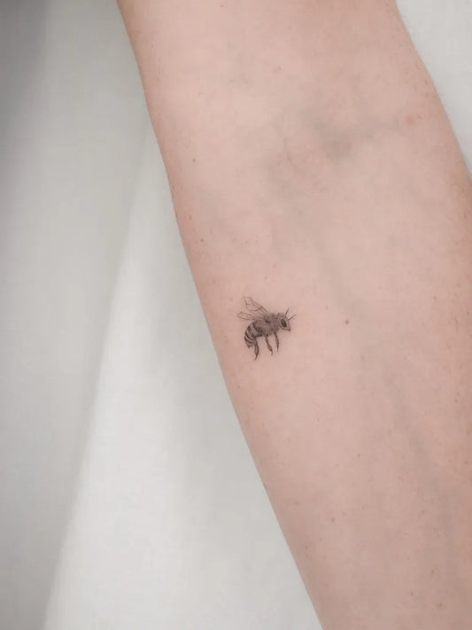 Small Minimalist Bee on Women Arm Tattoo by @inkandbella_