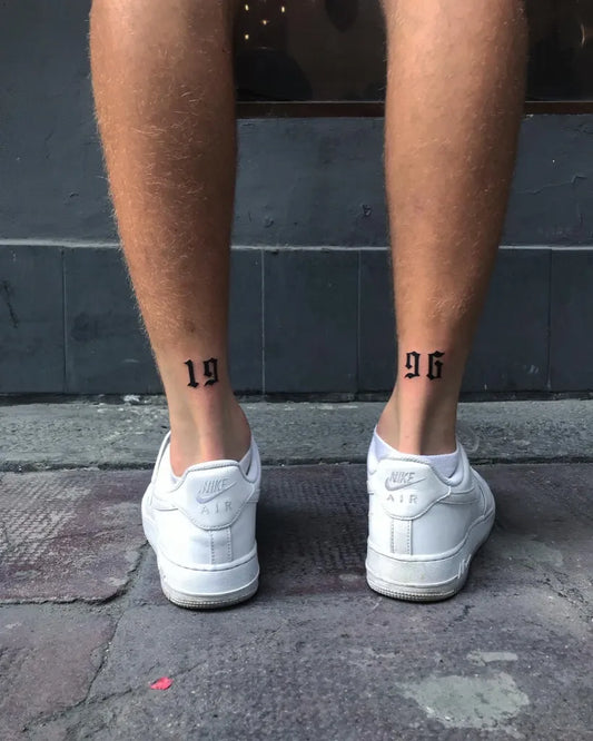 Small Minimalist Black Numbers Tattoo on Men Lower Legs by @zizusdrawing