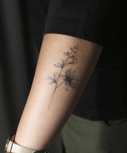 Small Minimalist Botanical Branch and Geranium Flower on Women Arm Tattoo by @jojoodeeb.inc