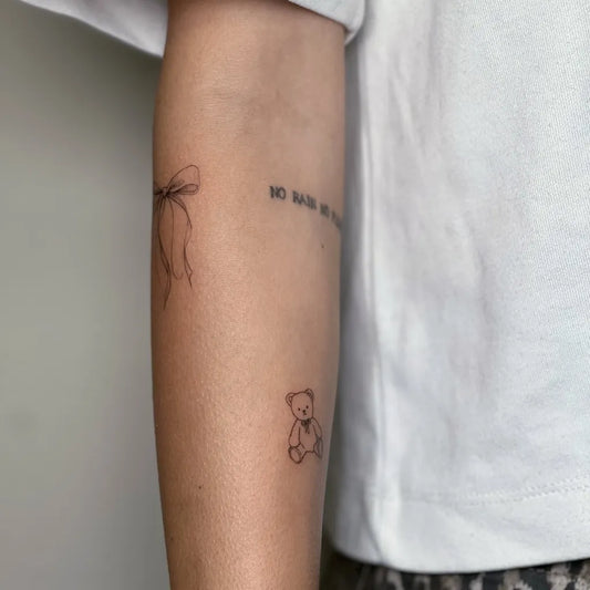 Small Minimalist Bow Ribbon Teddy Bear on Women Arm Tattoo by @mozetatuazyk