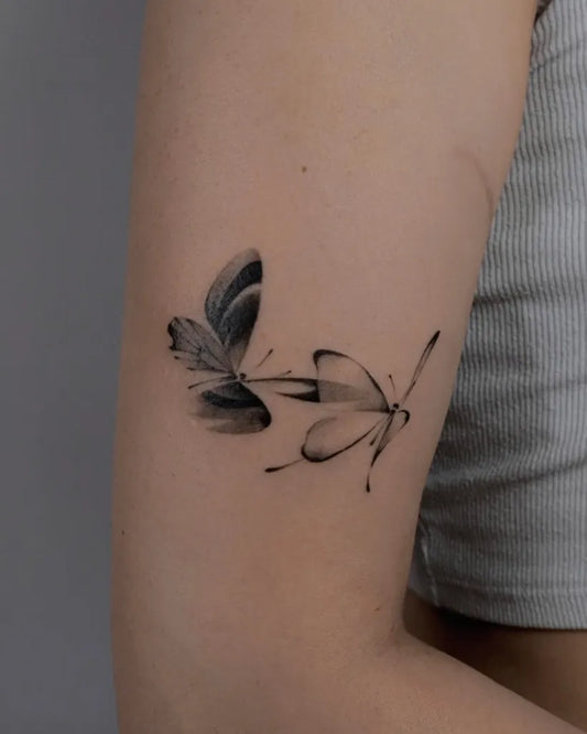 Small Minimalist Butterflies on Women Upper Arm Tattoo by @rivdttt