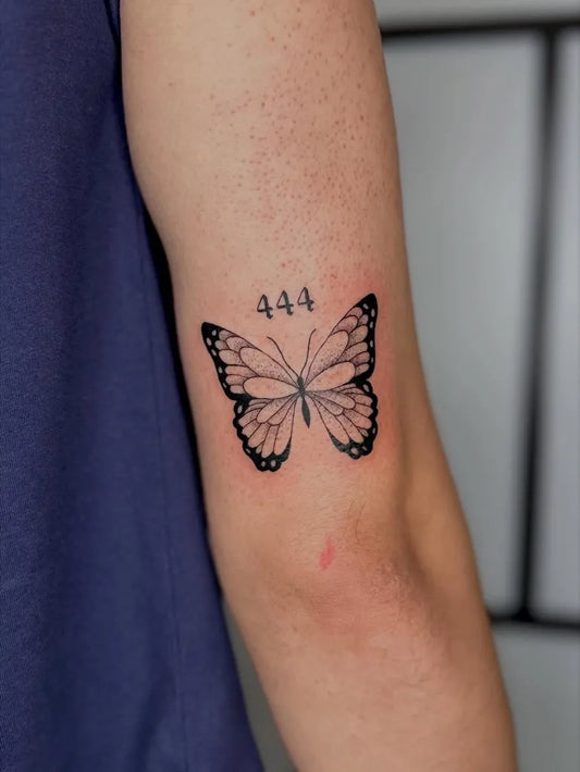 Small Minimalist Butterfly Number on Men Upper Arm Tattoo by @drogewijn.tattoo