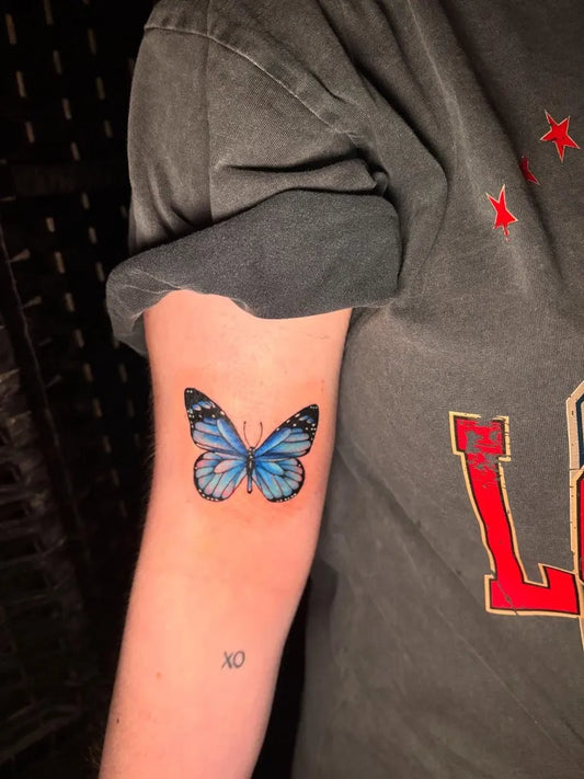 Small Minimalist Butterfly on Women Upper Arm Tattoo by @ha_tattooist