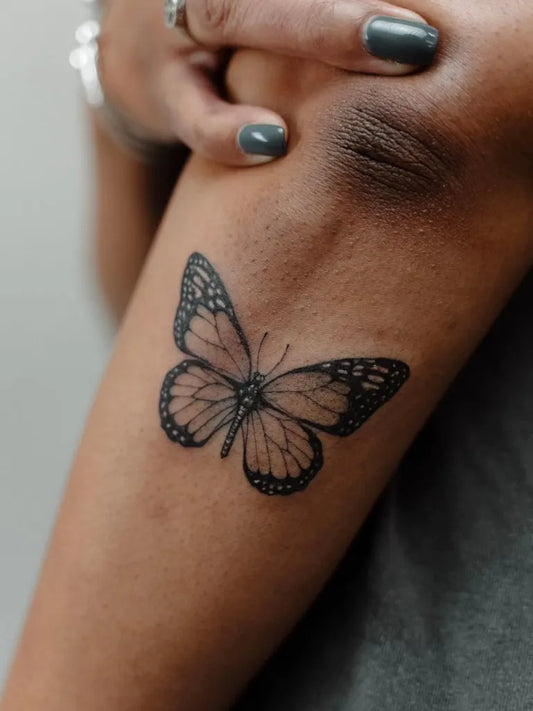 Small Minimalist Butterfly on Women Upper Arm Tattoo by @inkwellkingston
