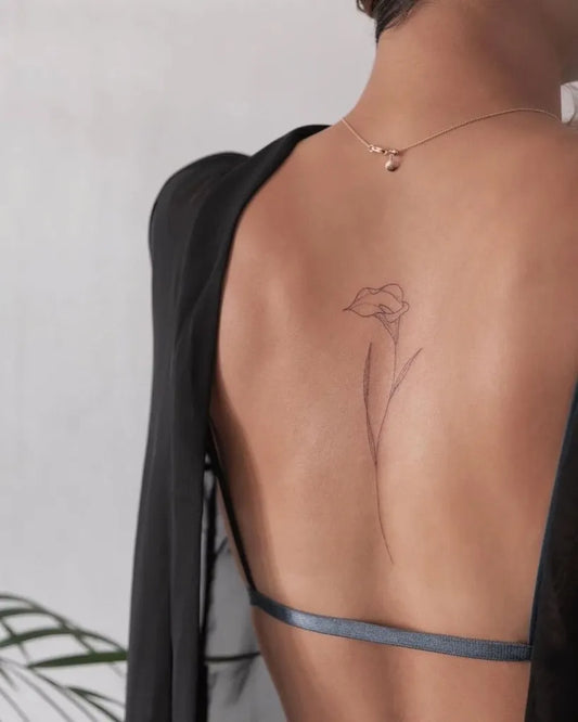 Small Minimalist Calla Lily on Women Back Tattoo by @tiny.tatts