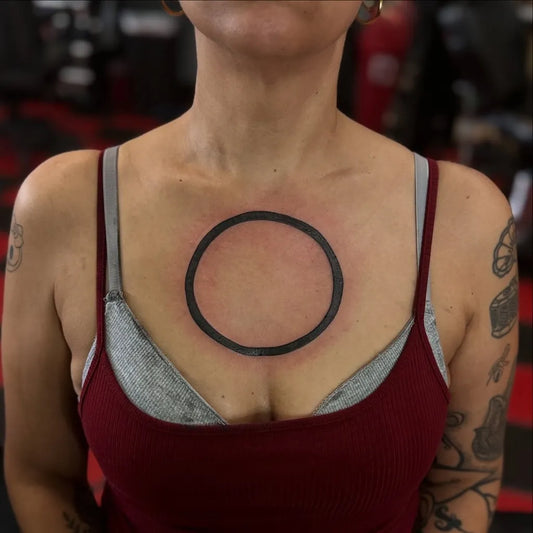 Small Minimalist Circle on Women Chest Tattoo by @creationtattoos