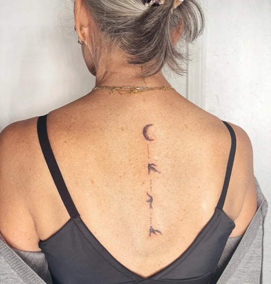 Small Minimalist Crescent Moon and Birds on Women Spine Tattoo by @inkedbyri.kc