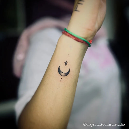 Small Minimalist Crescent Moon and Star Tattoo on Women Wrist by @dixys_tattoo_art_studio