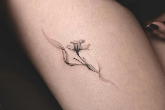 Small Minimalist Daffodil Tattoo on Women Thigh by @e.bin_ink