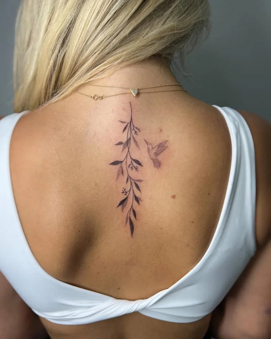 Small Minimalist Eucalyptus Hummingbird on Women Spine Tattoo by @mikel_ink_