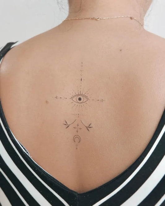Small Minimalist Evil Eye with Birds and Crescent on Women Back Tattoo by @cha.tattoo