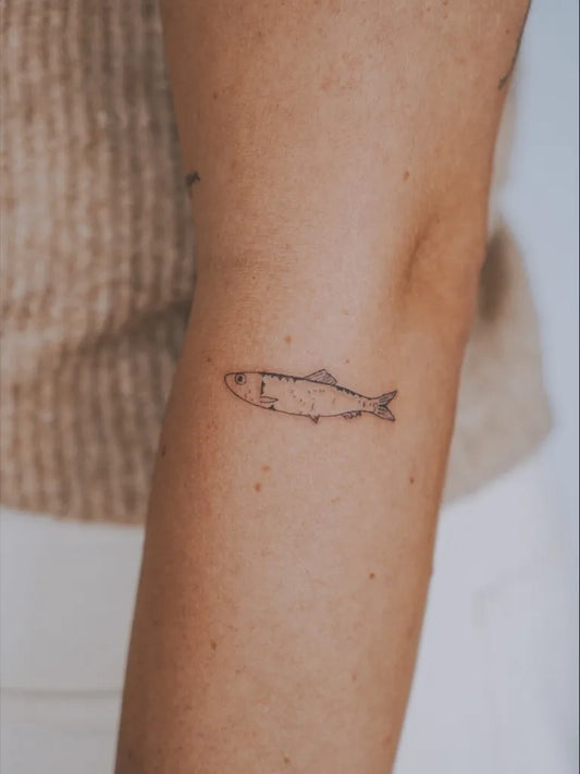 Small Minimalist Fish Tattoo on Women Arm by @calmyourtats