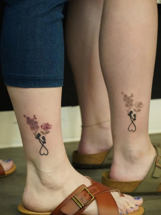 Small Minimalist Flower Silhouette Heart on Couple Leg Matching Tattoo by @ecoart_tattoo