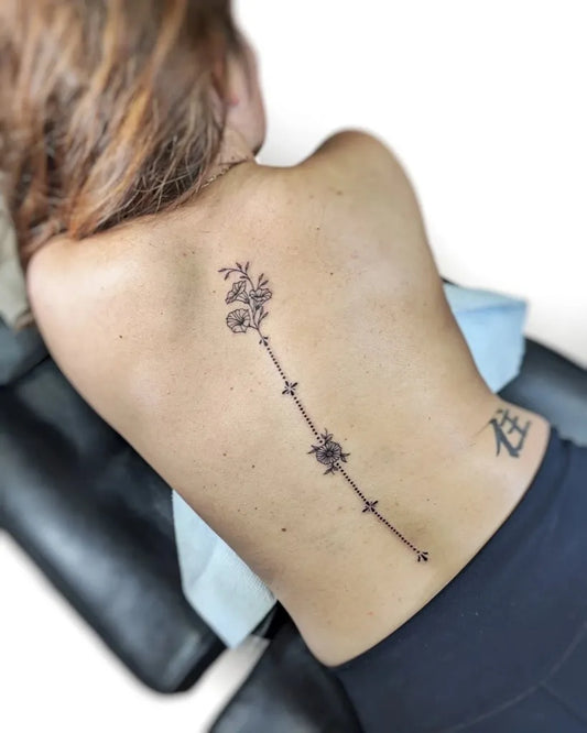 Small Minimalist Flowers and Kanji on Women Spine Tattoo by @whitemoontattoo