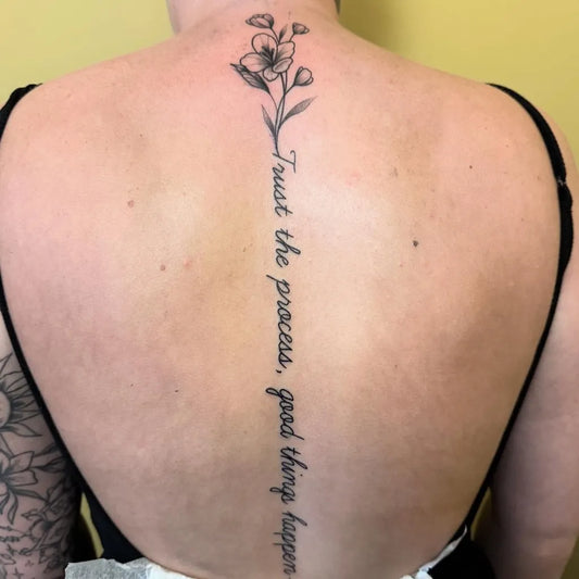 Small Minimalist Flowers and Quote on Women Spine Tattoo by @l.t.g.tattoos