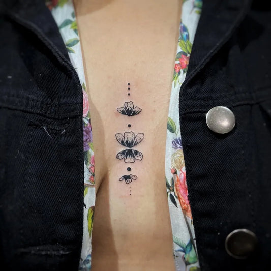 Small Minimalist Flowers on Women Sternum Tattoo by @bruna_et_spiritu