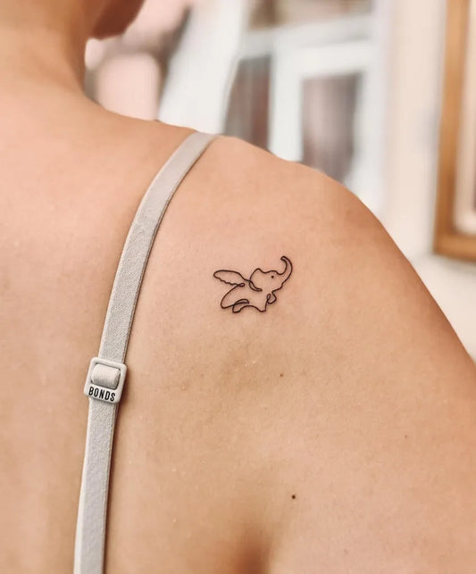 Small Minimalist Flying Elephant Tattoo on Women Shoulder by @bnanatattoo