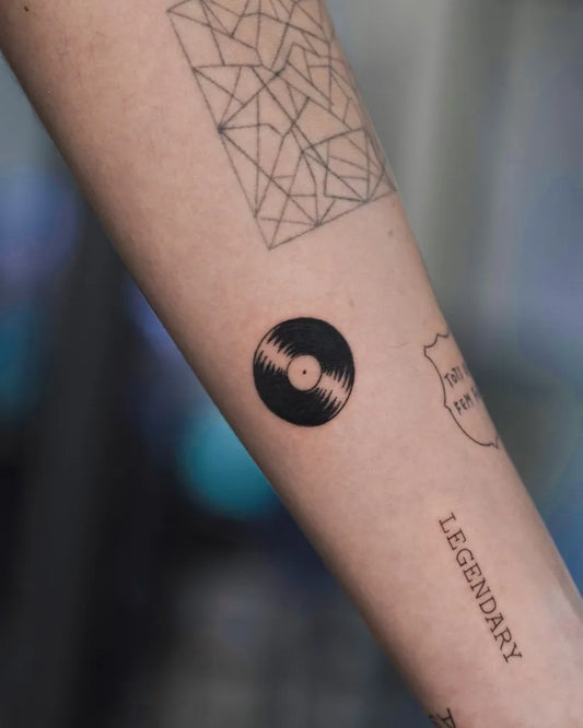 Small Minimalist Geometric Grid Vinyl Record Legend on Women Arm Tattoo by @bastian_fineline