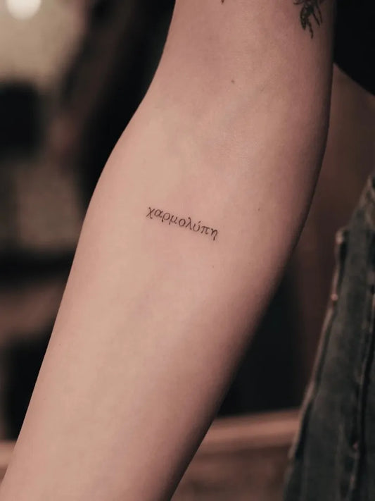 Small Minimalist Greek Text on Women Arm Tattoo by @davide_flowlines