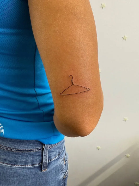 Small Minimalist Hanger on Women Arm Tattoo by @whitewardtattoo