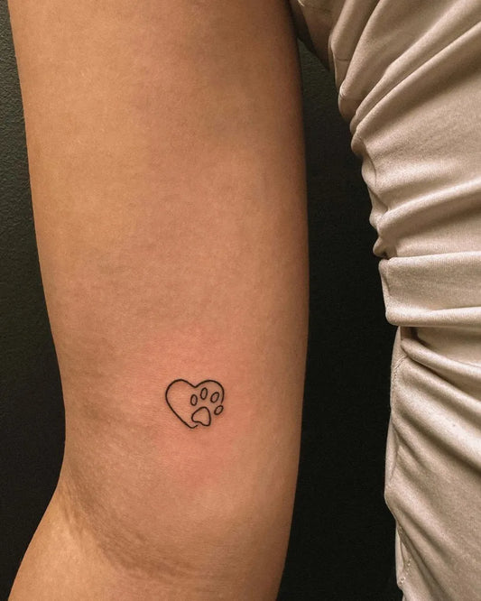 Small Minimalist Heart Paw on Women Arm Tattoo by @hybridink.helsinki