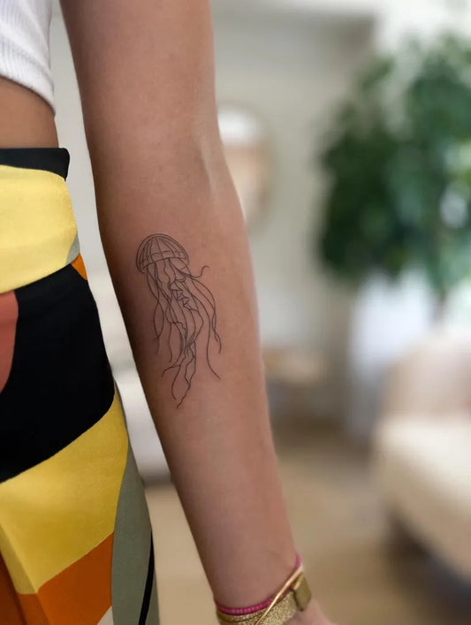 Small Minimalist Jellyfish on Women Arm Tattoo by @poemi.tattoo
