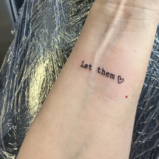 Small Minimalist Let Them Heart on Women Wrist Tattoo by @queenbeetattoostudio