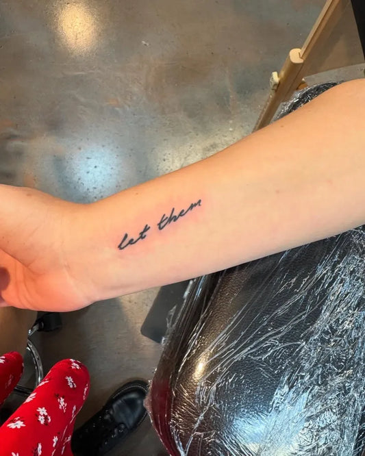 Small Minimalist Let Them on Women Wrist Tattoo by @deadivinatattoos