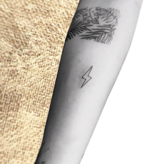 Small Minimalist Lightning Bolt Tattoo on Women Arm by @mirandapokes