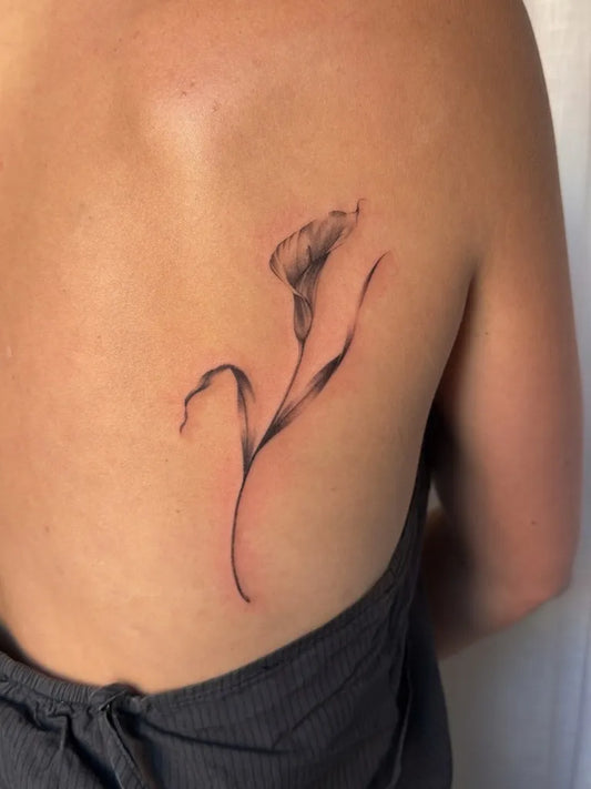 Small Minimalist Lineart Calla Lily on Women Shoulder Flower Tattoo by @zalitattoos