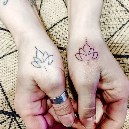Small Minimalist Lotus Flower with Dots on Women Wrist Tattoo by @ancestral.handpoke.tattoo