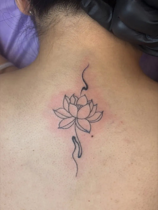 Small Minimalist Lotus Flower with Swirls on Women Back Tattoo by @angelagreytattoos