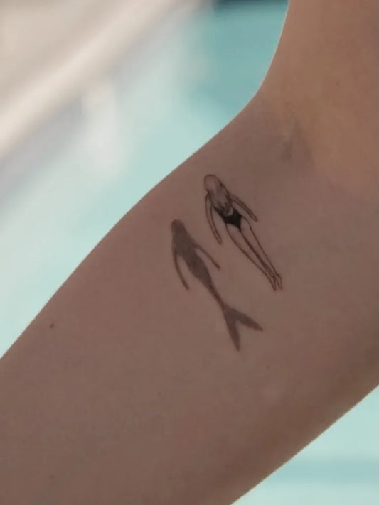 Small Minimalist Mermaid and Swimmer Tattoo on Women Arm by @vanessasigillo
