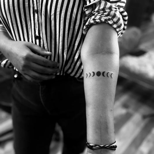 Small Minimalist Moon Phases Spiritual Tattoo on Women Arm by @bruna_et_spiritu