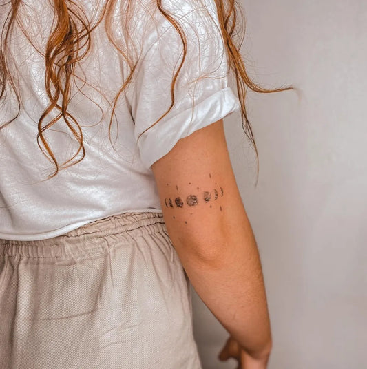 Small Minimalist Moon Phases Tattoo on Women Arm by @annacalado.ink