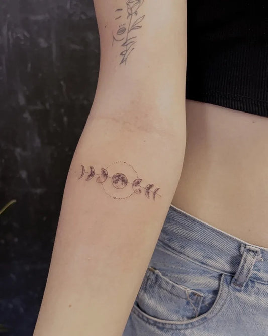 Small Minimalist Moon Phases Tattoo on Women Arm by @factory.tattoos