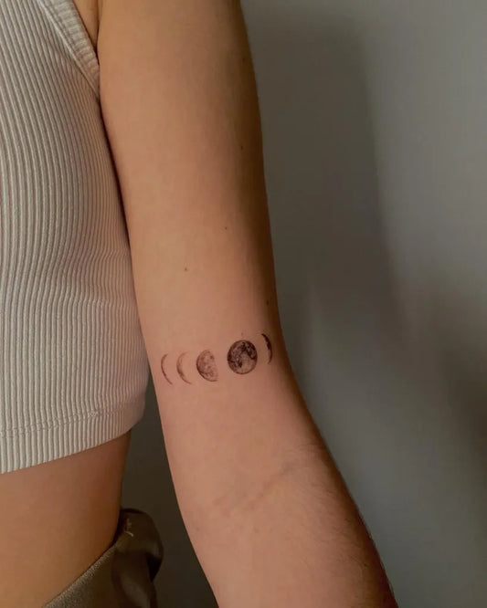 Small Minimalist Moon Phases Tattoo on Women Arm by @vvinkxo