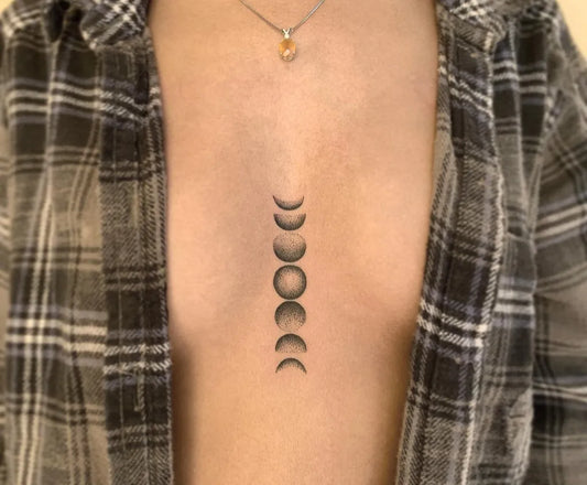 Small Minimalist Moon Phases Tattoo on Women Chest by @artorcry