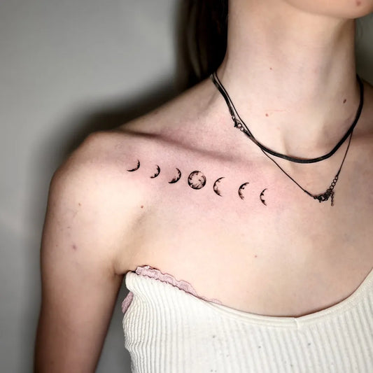 Small Minimalist Moon Phases Tattoo on Women Collarbone by @inkgenics