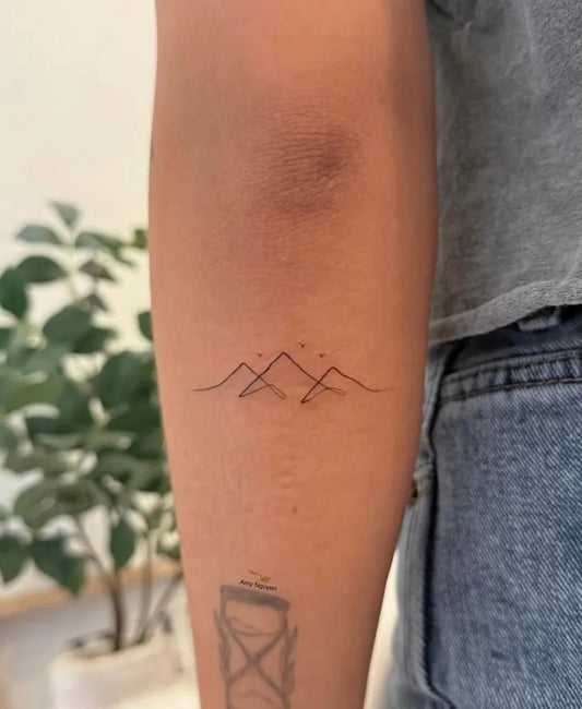 Small Minimalist Mountain Range Tattoo on Women Arm by @tinytattoo.mailash