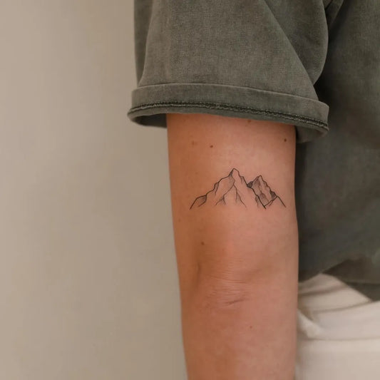 Small Minimalist Mountain Tattoo on Women Arm by @maxime.tattoo