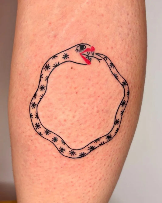 Small Minimalist Ouroboros Tattoo on Women Leg by @mama.mahluk.tattoo