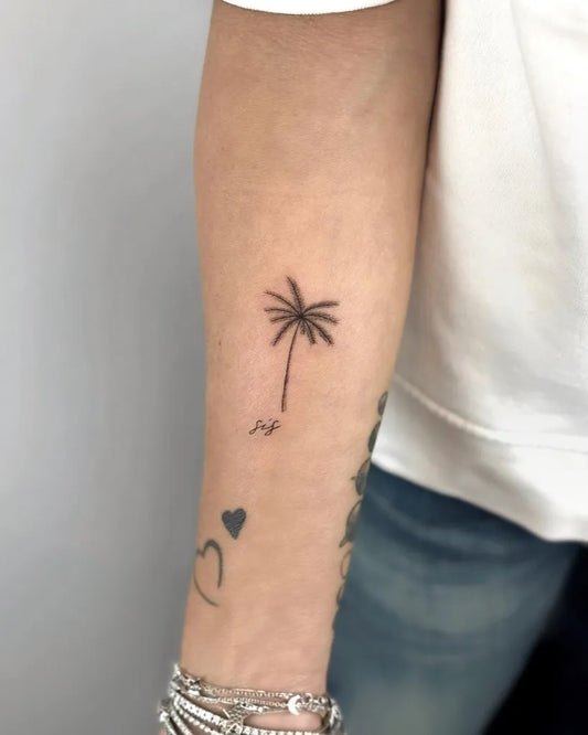 Small Minimalist Palm Tree Heart Tattoo on Women Arm by @cha.tattoo