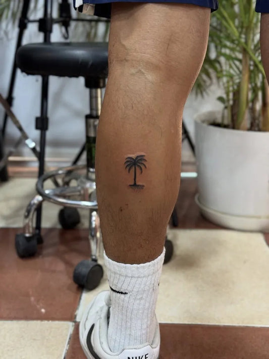 Small Minimalist Palm Tree Tattoo on Men Leg by @dr_g_tattoo_hurghada